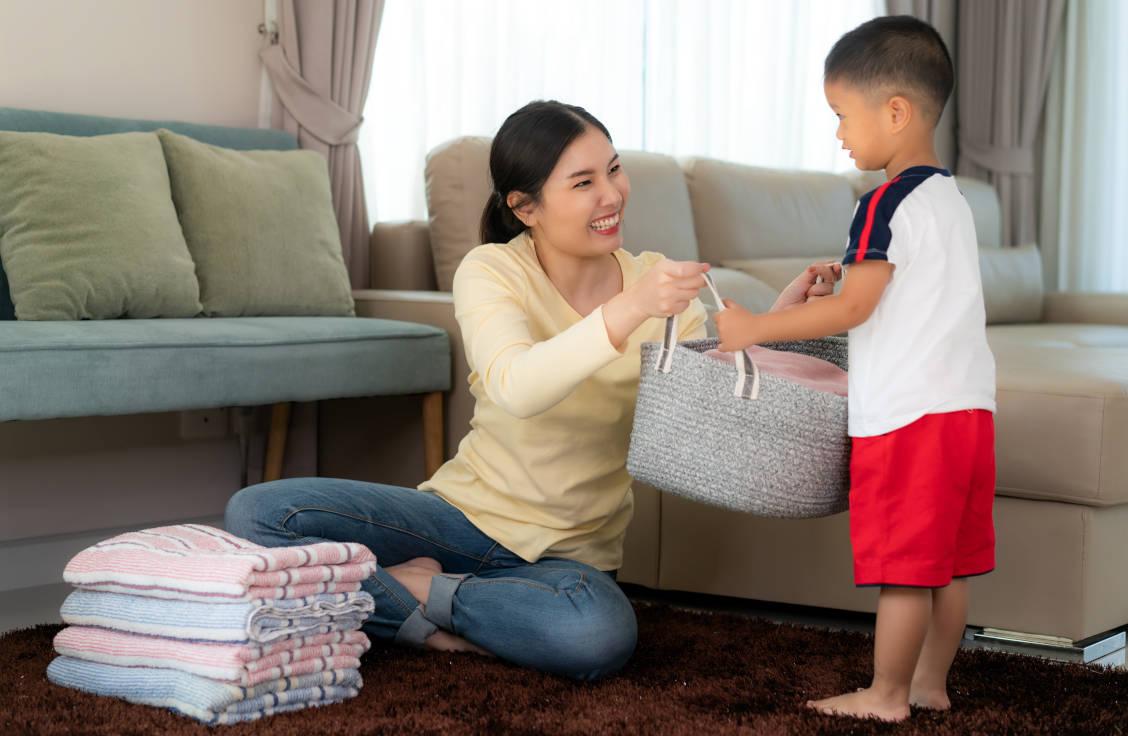 Seorang ibu sedang mengajarkan anak laki-laki untuk membantu