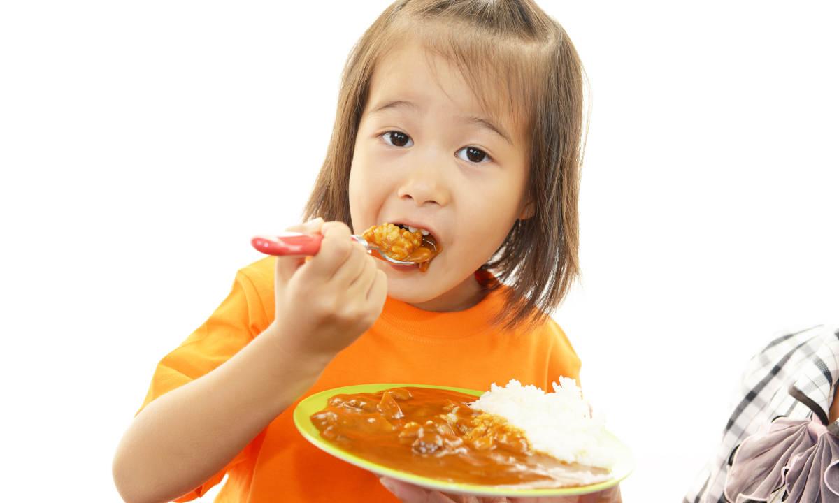 Seorang anak sedang makan makanan pedas